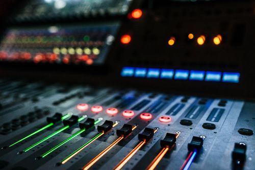 Beleuchtete Fader und LEDs eines Mischpults in Nahaufnahme